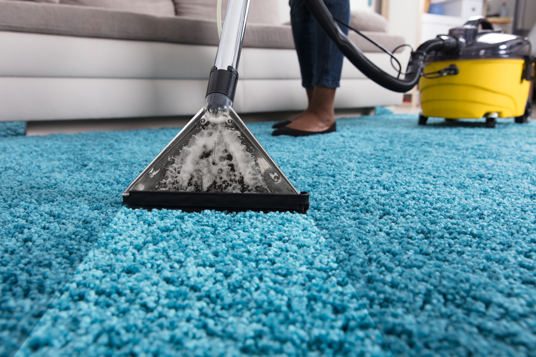 Person Using Vacuum Cleaner For Cleaning Carpet